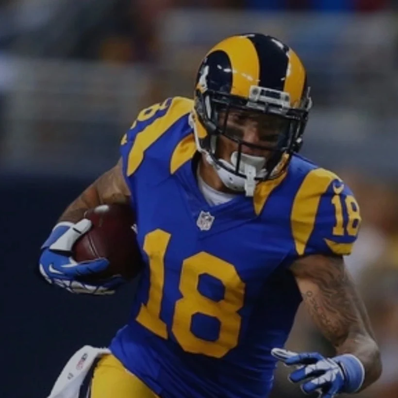 Former NFL player Austin Pettis running with the football in his blue and yellow Rams uniform.